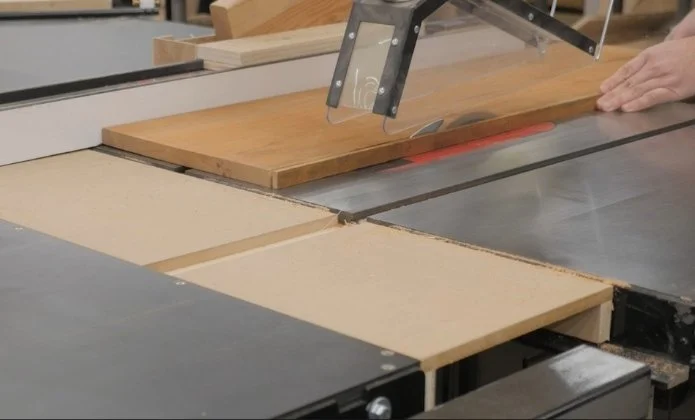 ripping a board along the length of a board on a table saw