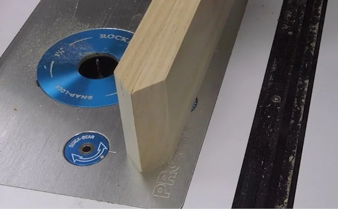 two pieces with mitered edges attached back to back on top of a router table