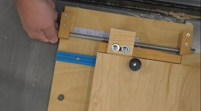 a hand rotating the fixed threaded rod on the incremental jig to micro-adjust the measurement