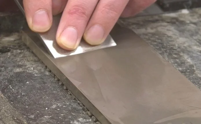 freehand sharpening a chisel on a diamond stone