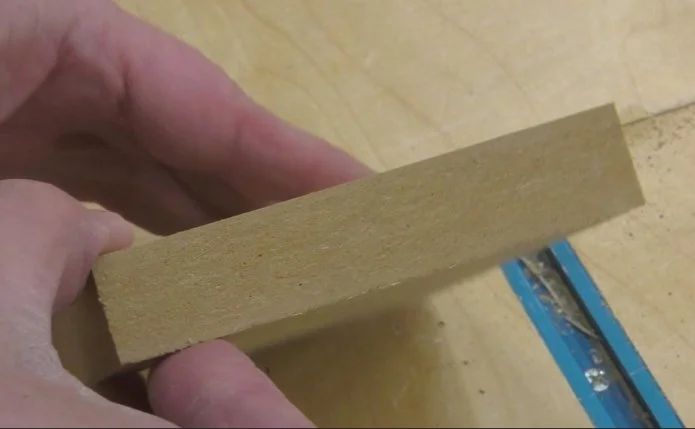 the edge of a piece of MDF showing that MDF lacks long continuous fibers running through the board.