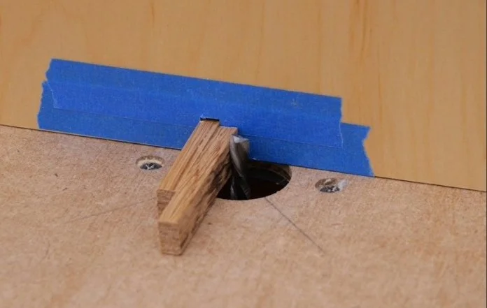 Using a piece of wood the same size as the indexing pin in a router fence as a spacer before cutting a kerf