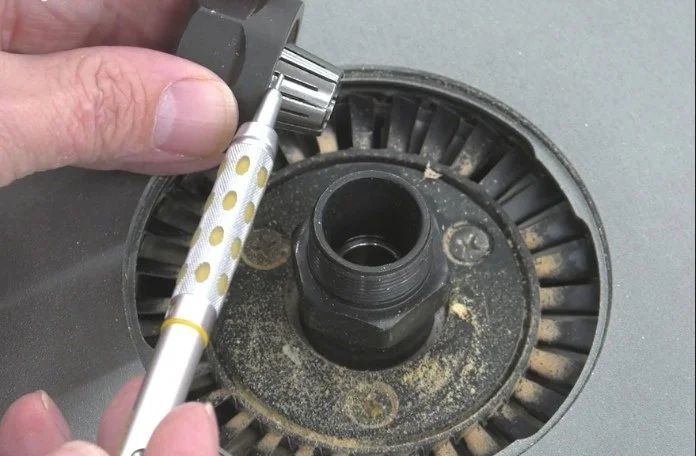 a pencil pointing at the tapered exterior of a collet in relation to the end of a router's motor shaft.