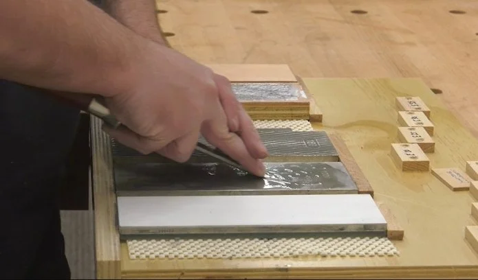 keeping fingers close to the edge of the chisel to maintain control while sharpening