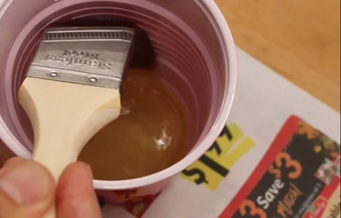 sloshing a paint brush that was in oil based poly into a red solo cup that contains mineral spirits