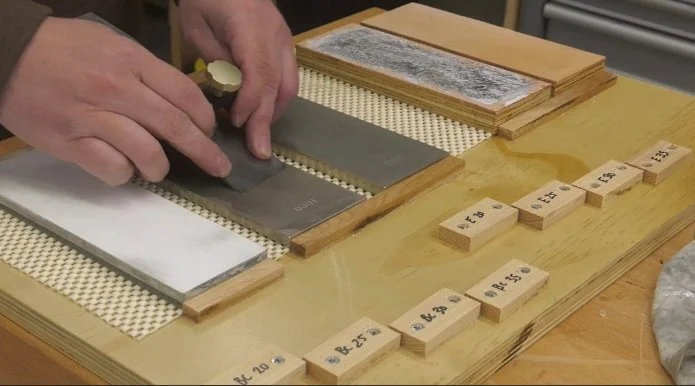 a honing board featuring different stop gauges, diamond stones, and strops with paste