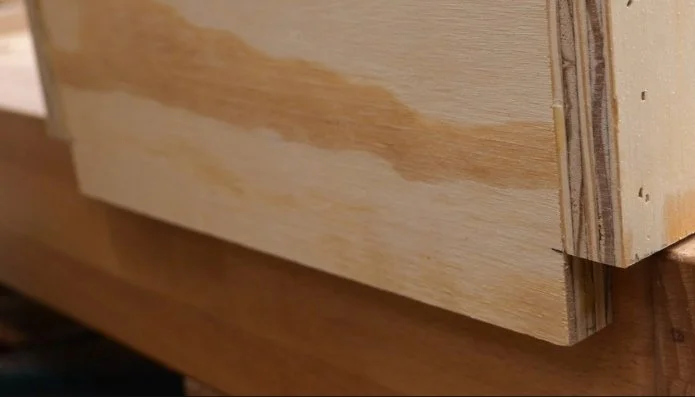 a router table rail made of plywood, mounted about an inch lower than the sides so that it can hook onto a bench top