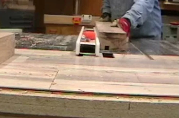 a man cutting a piece of wood on a typical american table saw with long fence