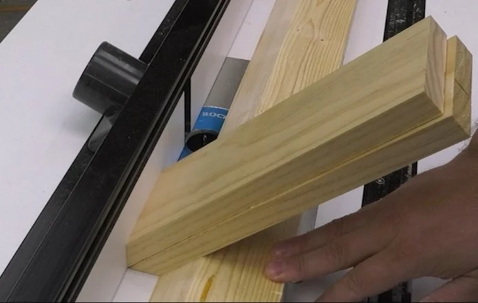 setting up a 2 x 6 with a 45 degree bevel on the router table as a guide for cutting splines on mitered workpieces