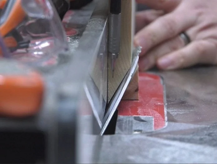 demonstrating when you cut an acute angle, you're removing the entire edge of the workpiece