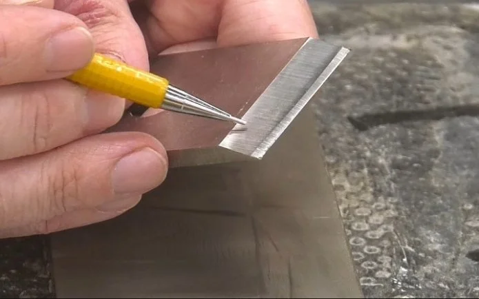 a pencil pointing at a micro-bevel on the edge of a plane iron