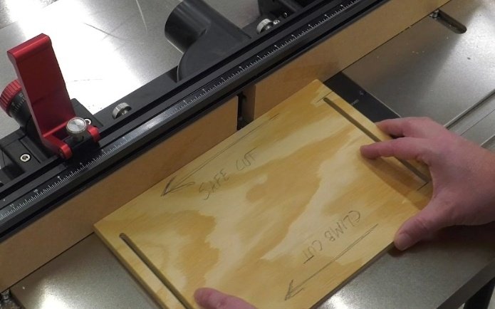 a piece of plywood with writing on it to indicate which direction is safe to cut on a router table