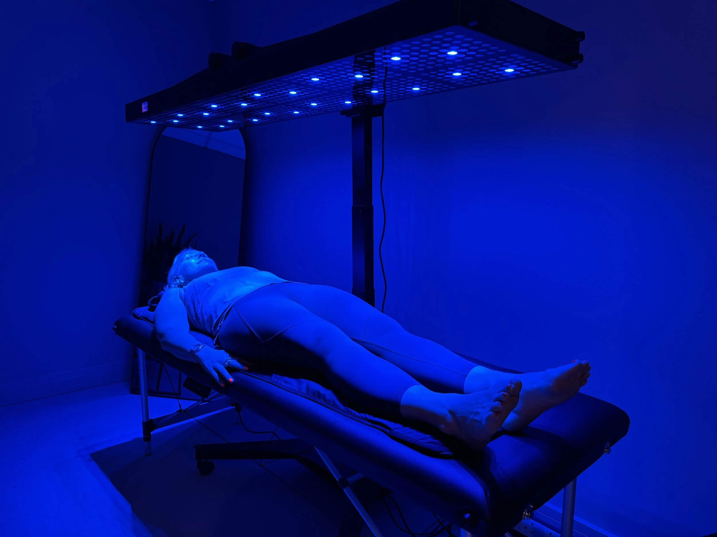 Client receiving blue light therapy to support acne-prone skin and reduce acne-causing bacteria