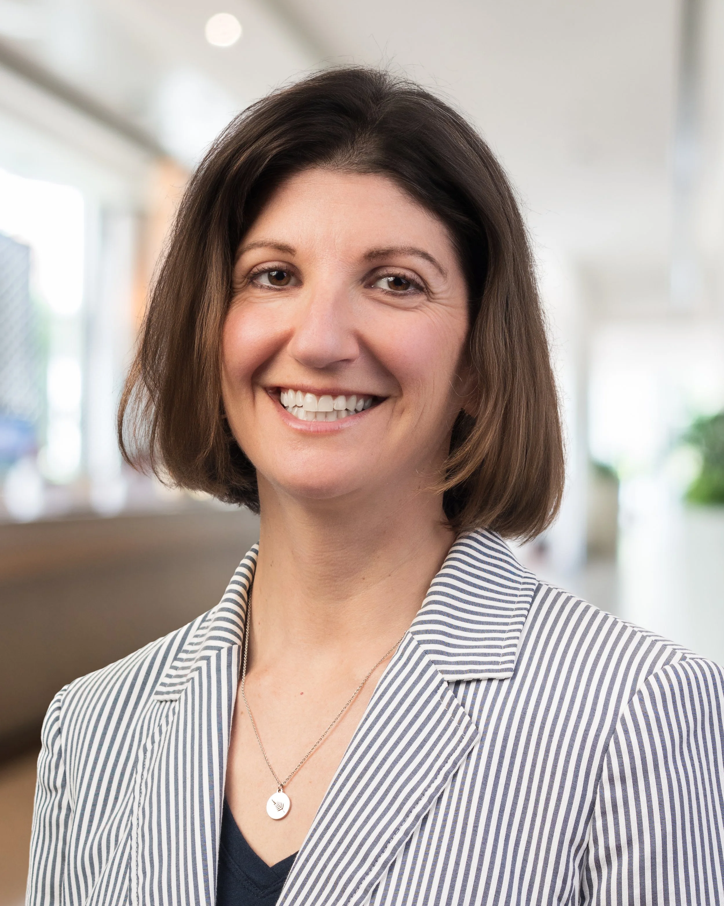 Headshot of a professional woman taken indoors with blurred office background