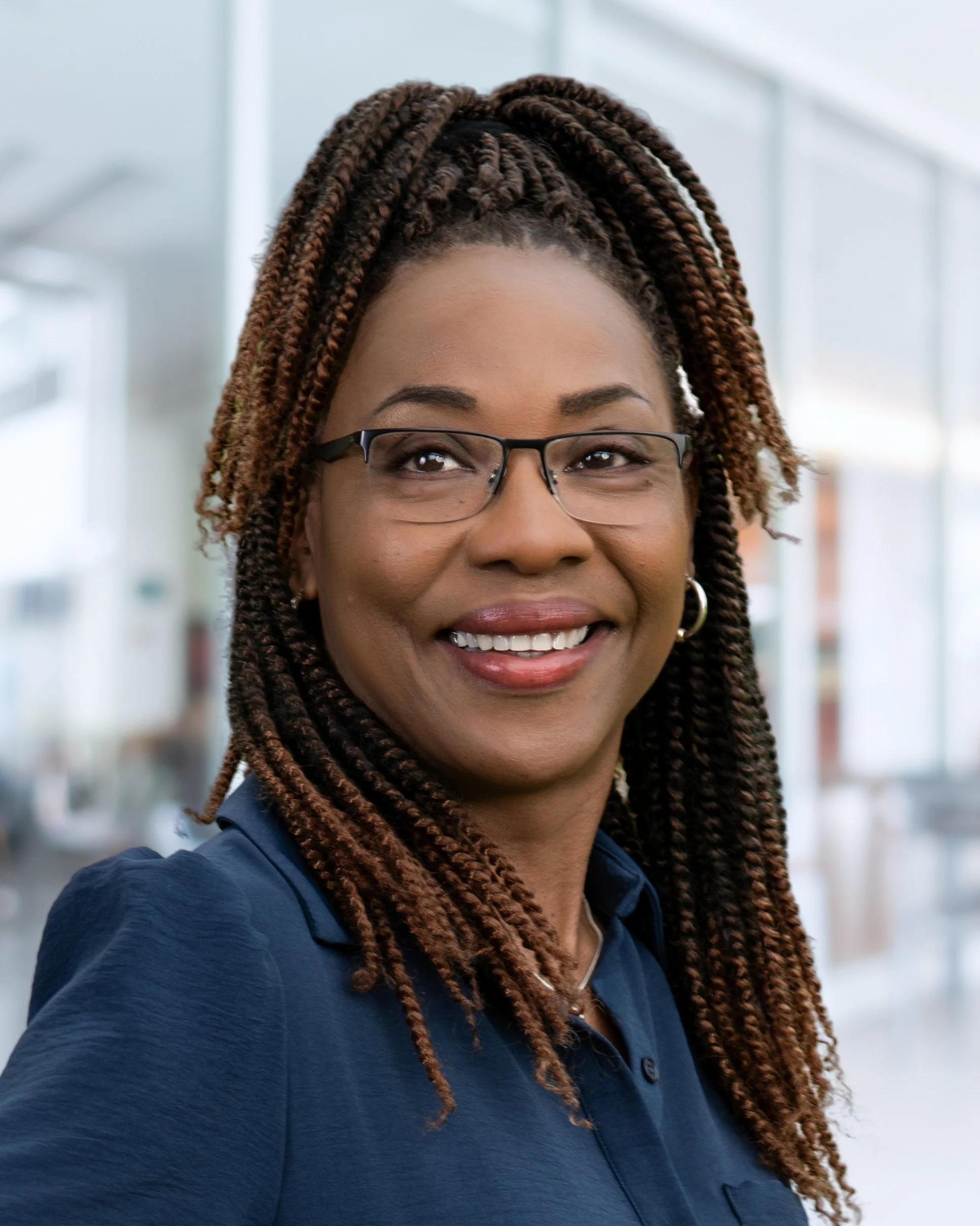 Headshot of a professional woman taken indoors with blurred office background
