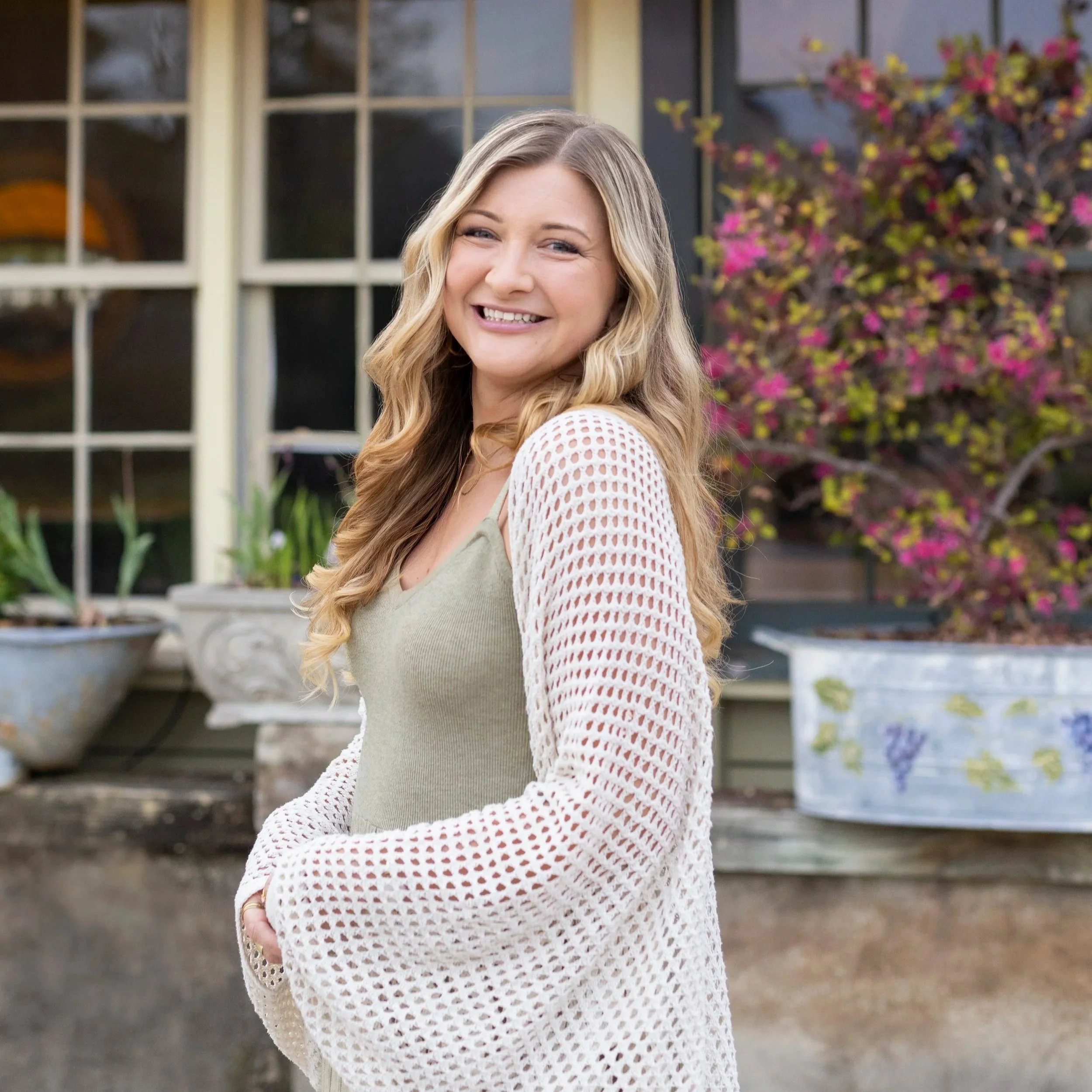 realtor, Clara Harrison standing in front of windows and plants