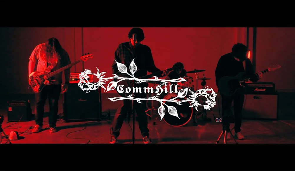 A band performs on stage with red lighting, including a drummer, bassist, and two guitarists, with a logo reading 'Commsill' overlaid.