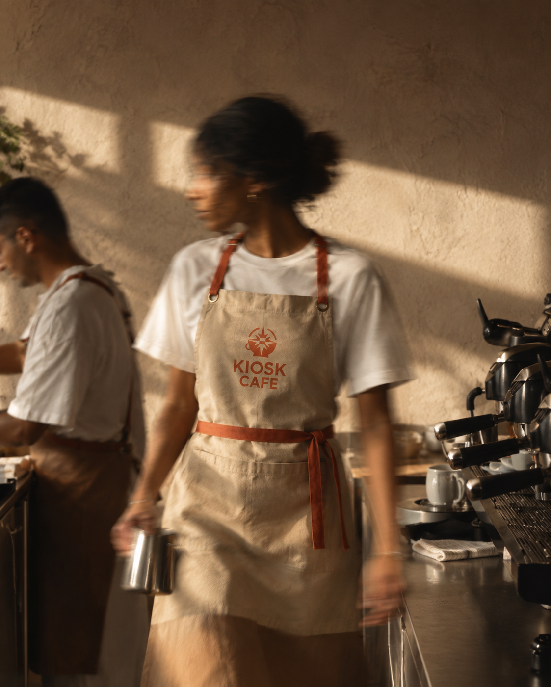 Cafe employee wearing branded apron