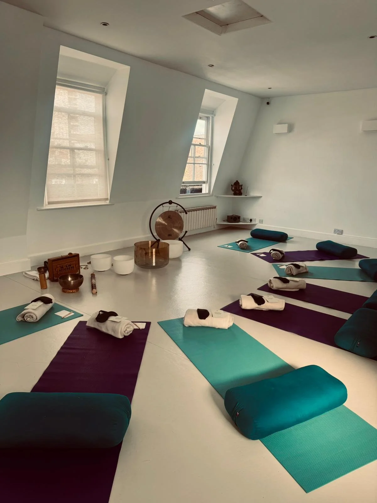 yoga studio with colourful mats and singing bowls
