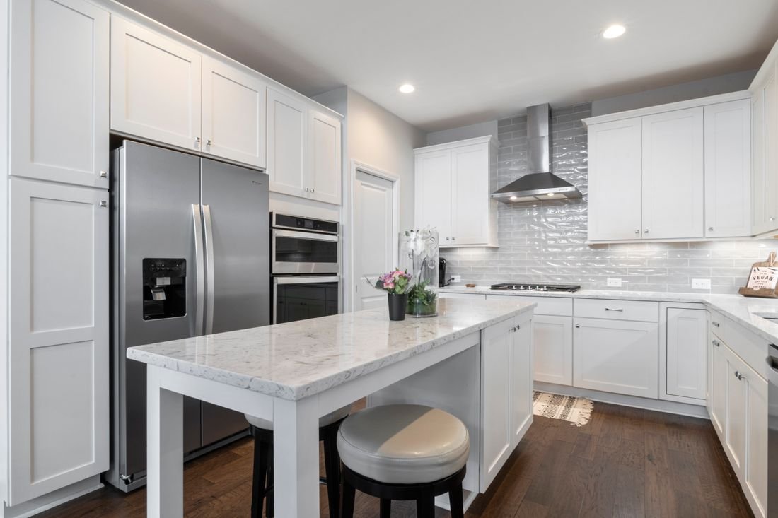 High-end kitchen with refrigerator, ovens, and cooktop