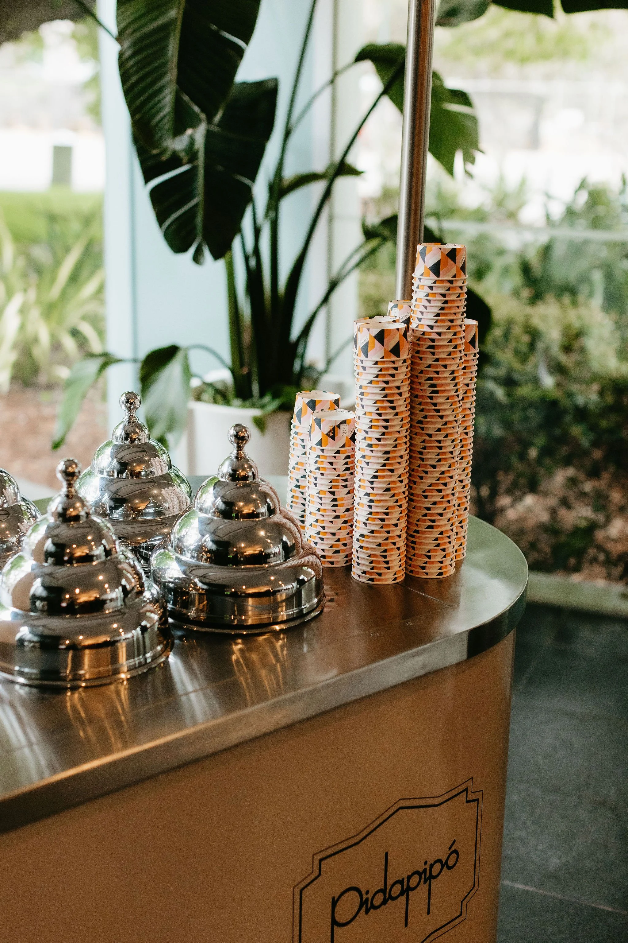 Image of a vintage Gelato Cart by Pidapipo sitting in the corner of the welcome foyer at Zinc. Ice Cream cups are stacked to the side, large pot plants and floor to ceiling windows provide a tranquil backdrop.