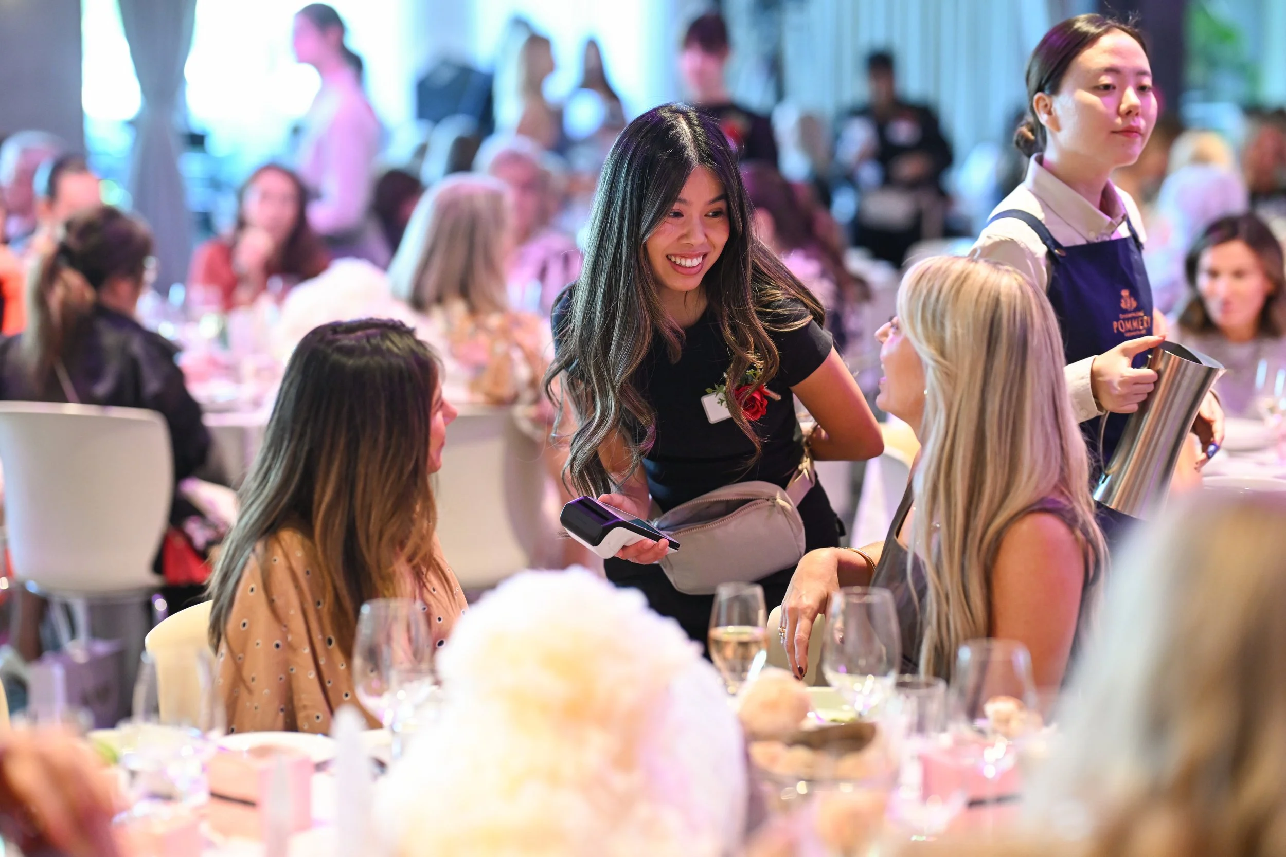 Photo of a white long fundraiser table set up with modern sleek table setting and elegant lighting