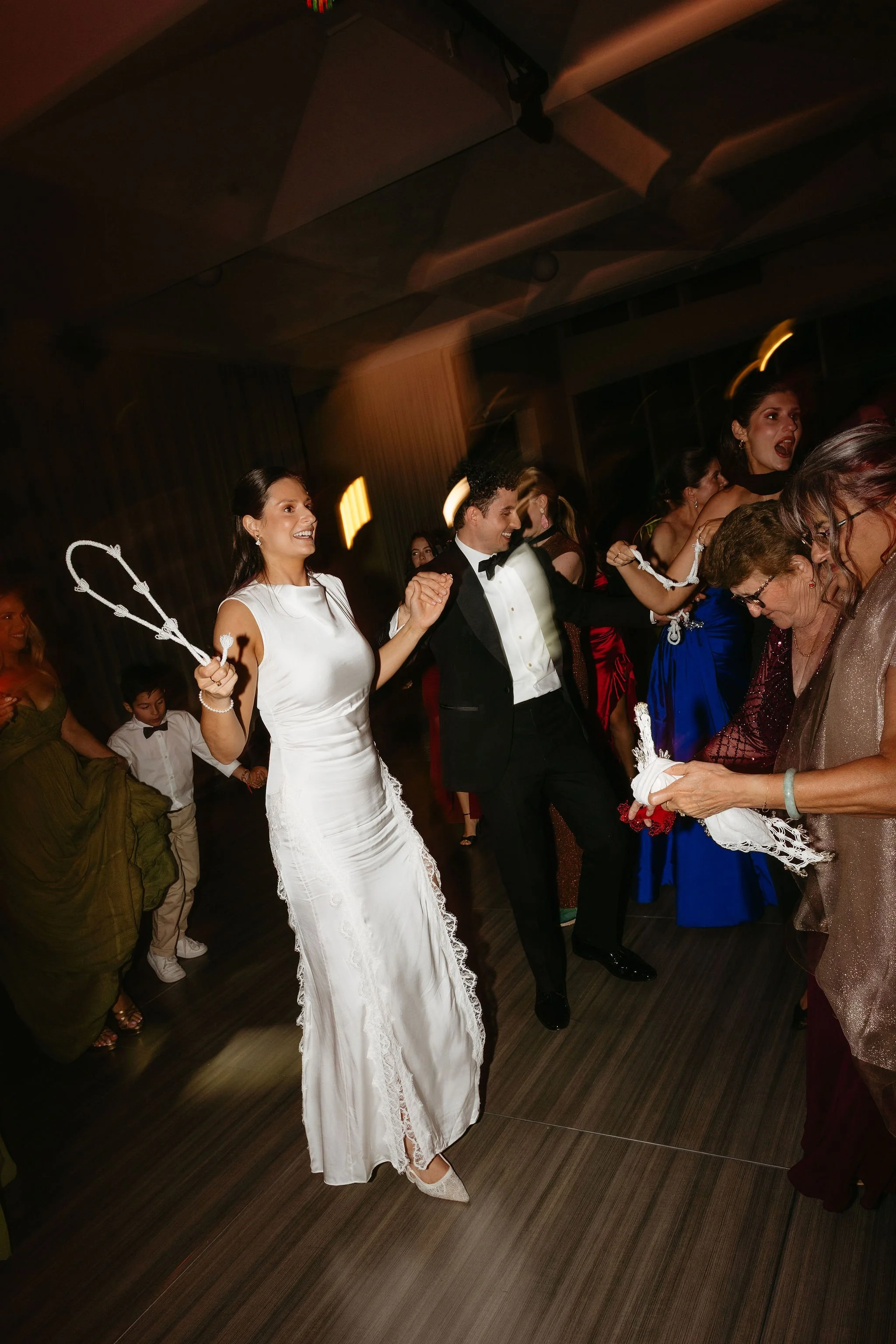 Bride and groom traditional greek dance set - Bride wears elegant second dress by Shona Joy. Groom wears suit by P.Johnson Tailors.