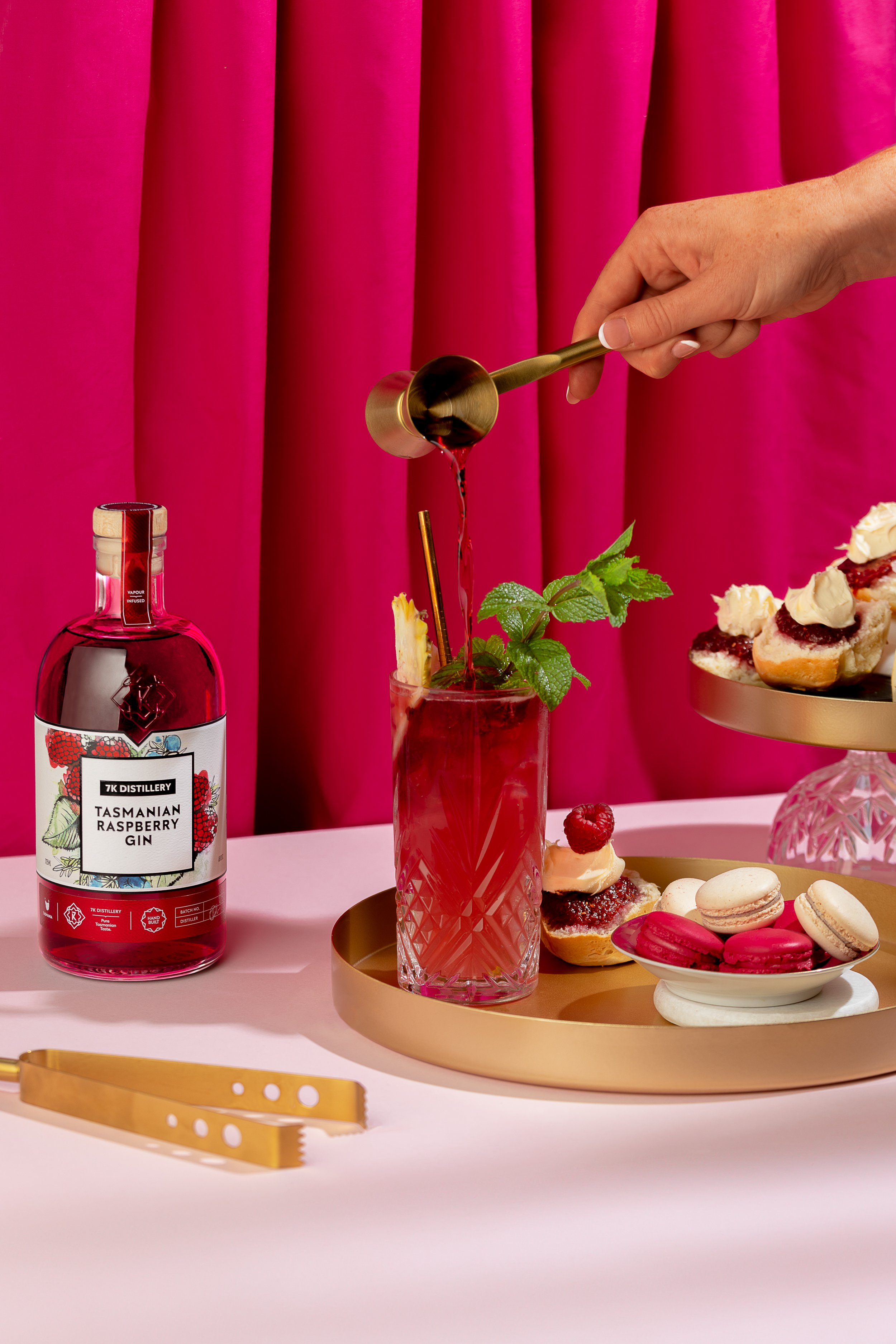 A 7K raspberry cocktail is poured into a glass.
