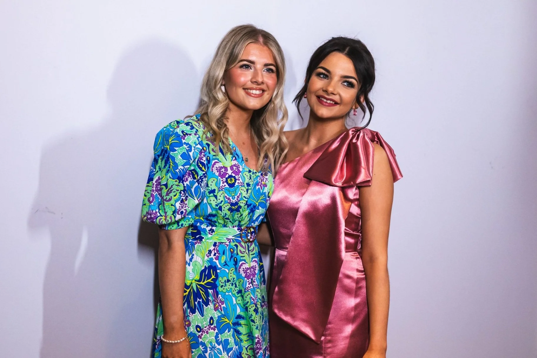 2 women taking a photo at a wedding photo booth