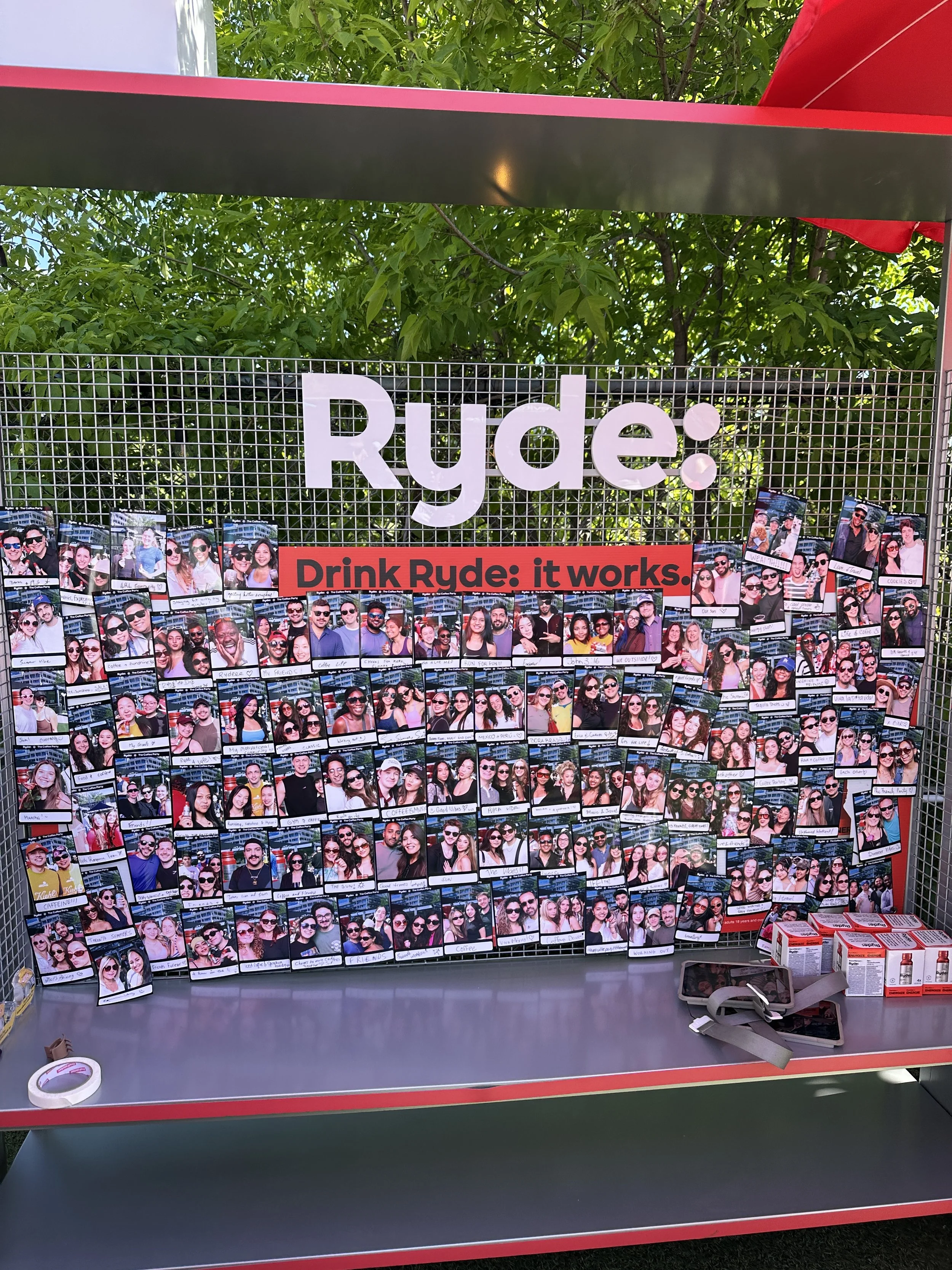 Display board covered with branded photo booth prints at Ryde Coffee Party Toronto activation