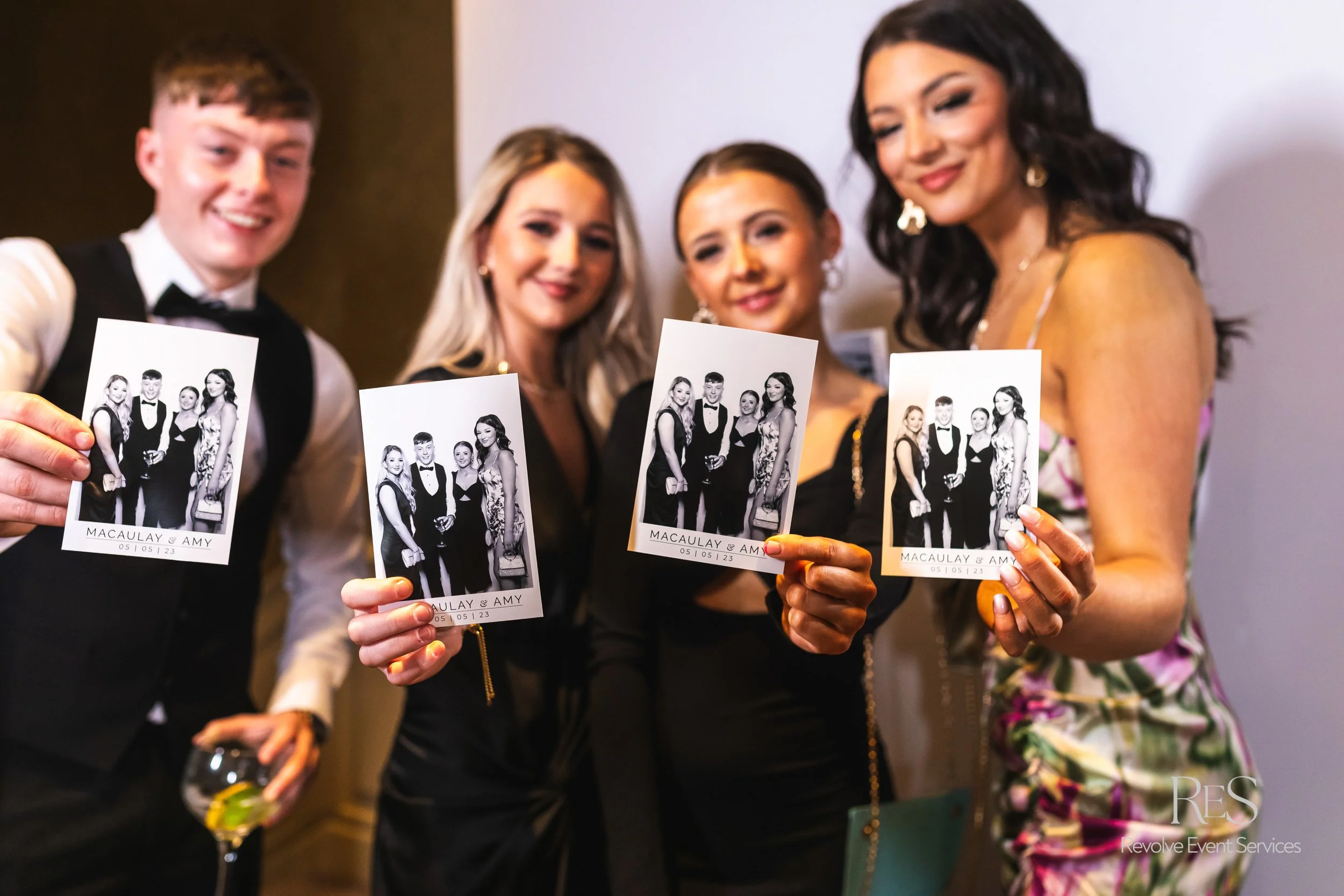 Guests holding photo booth prints at a Toronto event