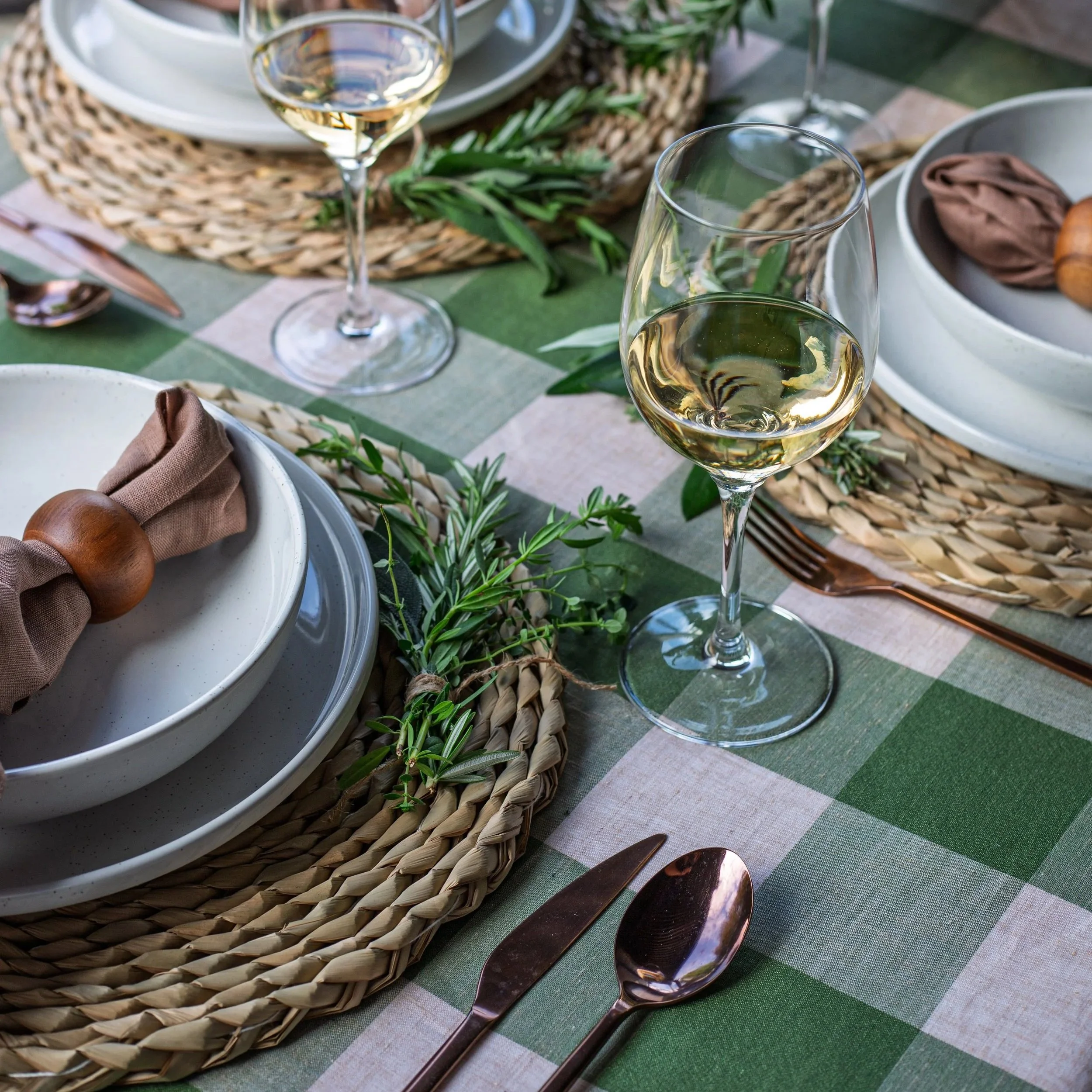 Luxe tropical set up with rattan plate holders, white stoneware range with palm spring decor for our Coco Club tablescape package by Fancy Neighbour