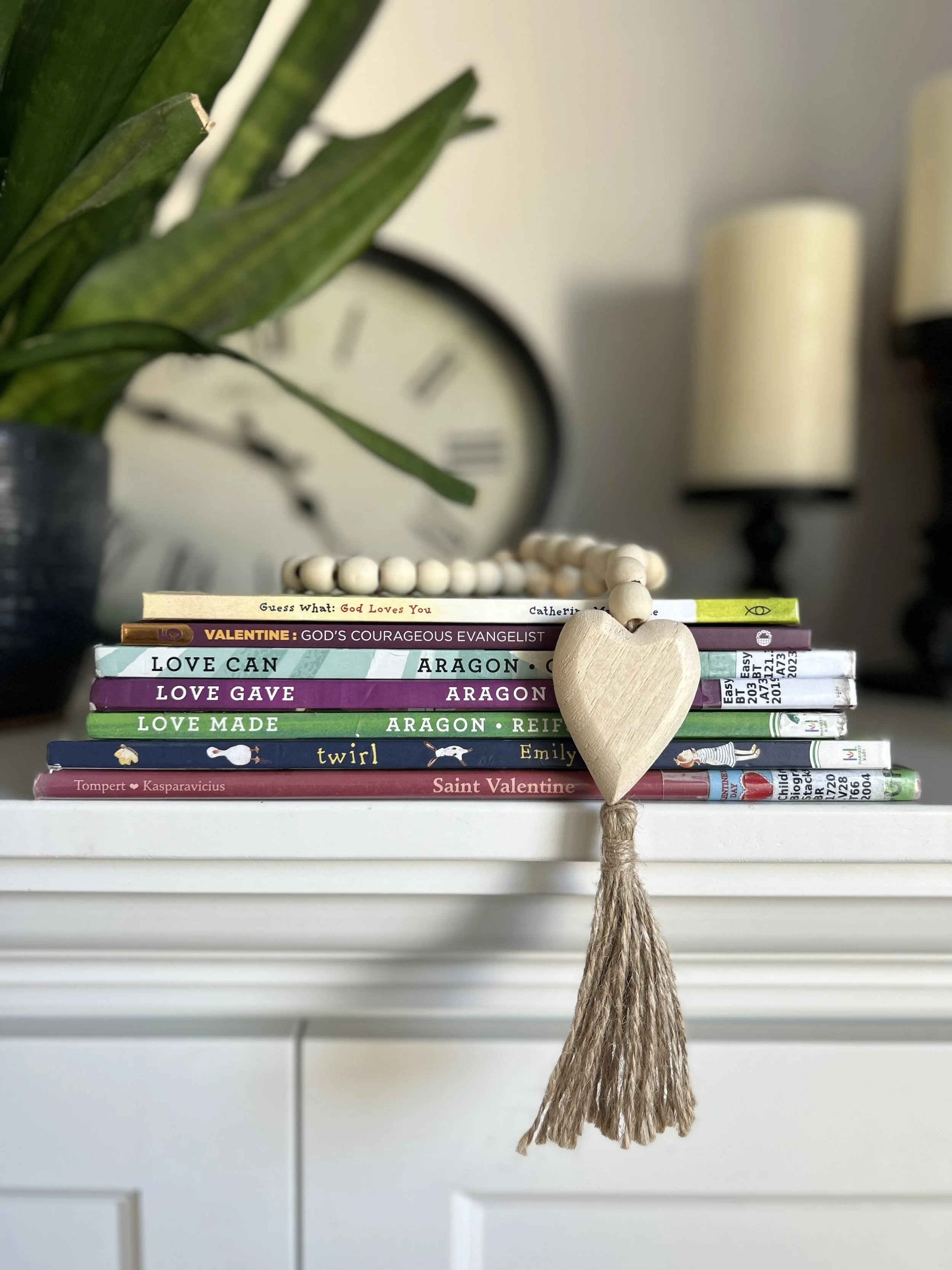 A stack of Valentine’s Day picture books for kids featuring themes of love, family, and faith