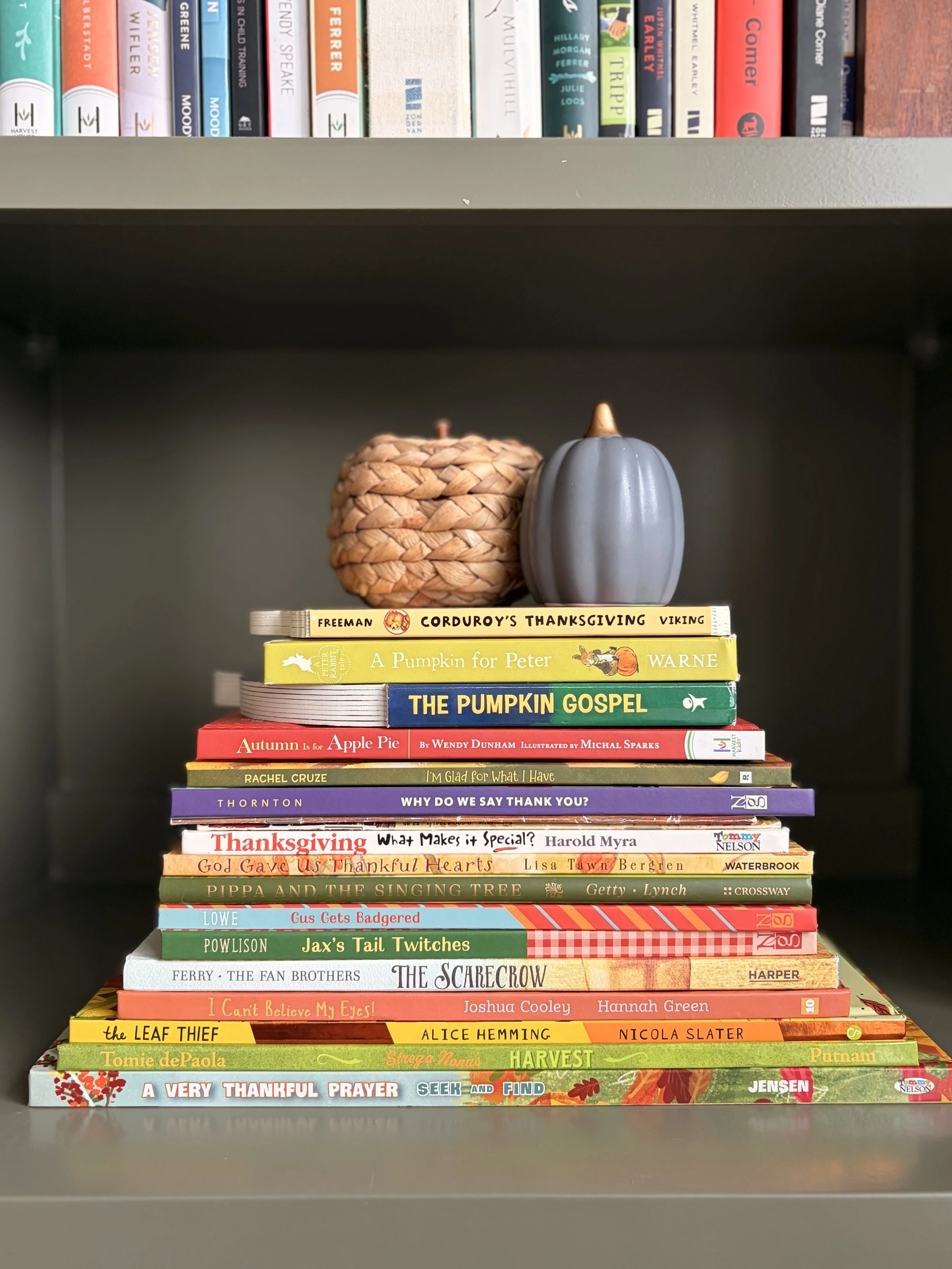 Stack of fall-themed children's picture books with pumpkins and autumn leaves