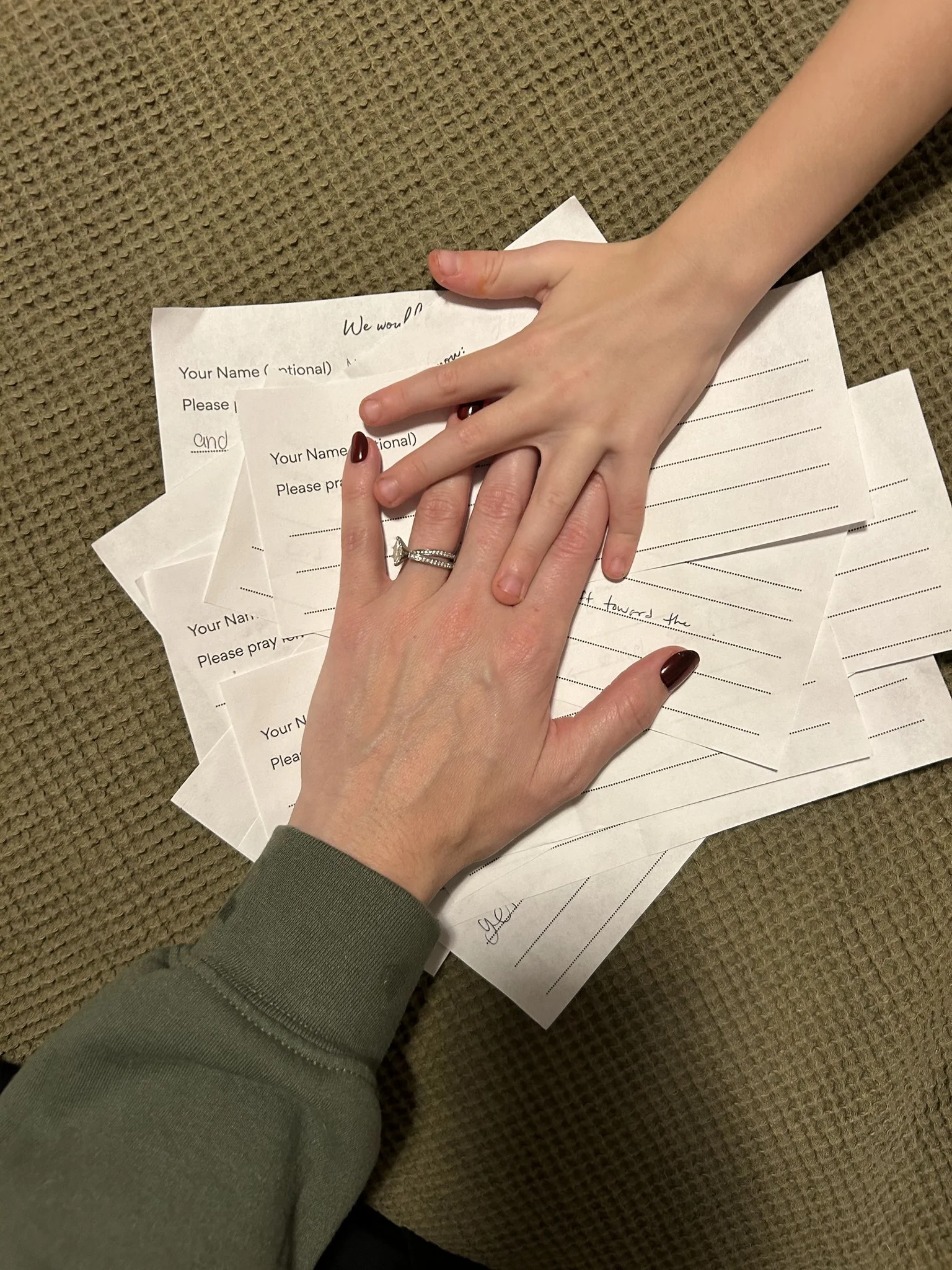 Hands covering prayer request slips for Halloween from neighbors