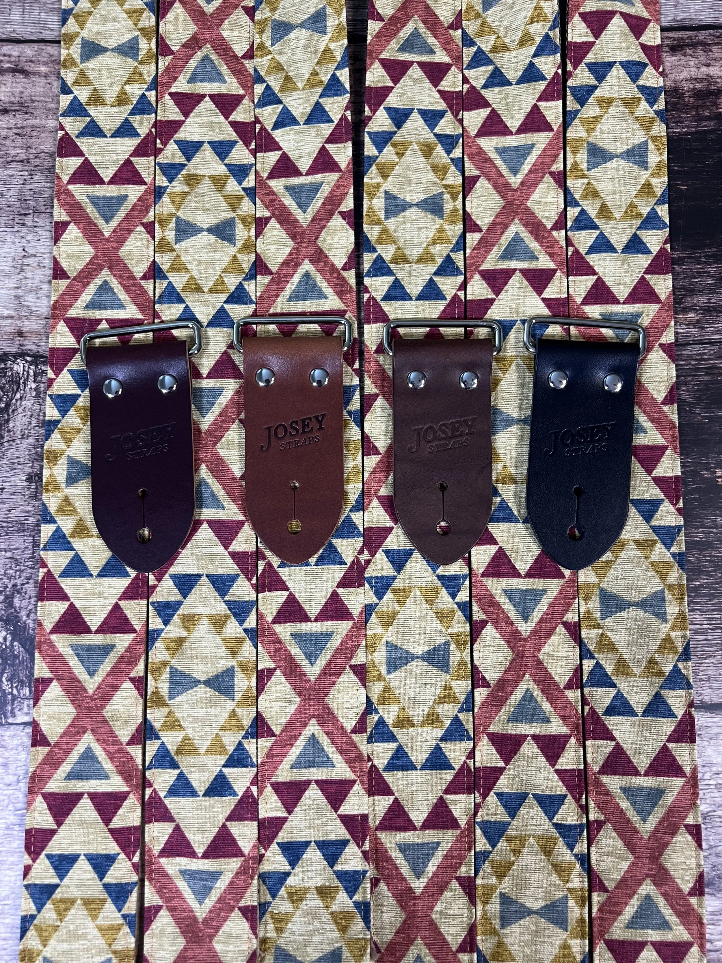 three guitar straps laid out on wood background showing leather end options