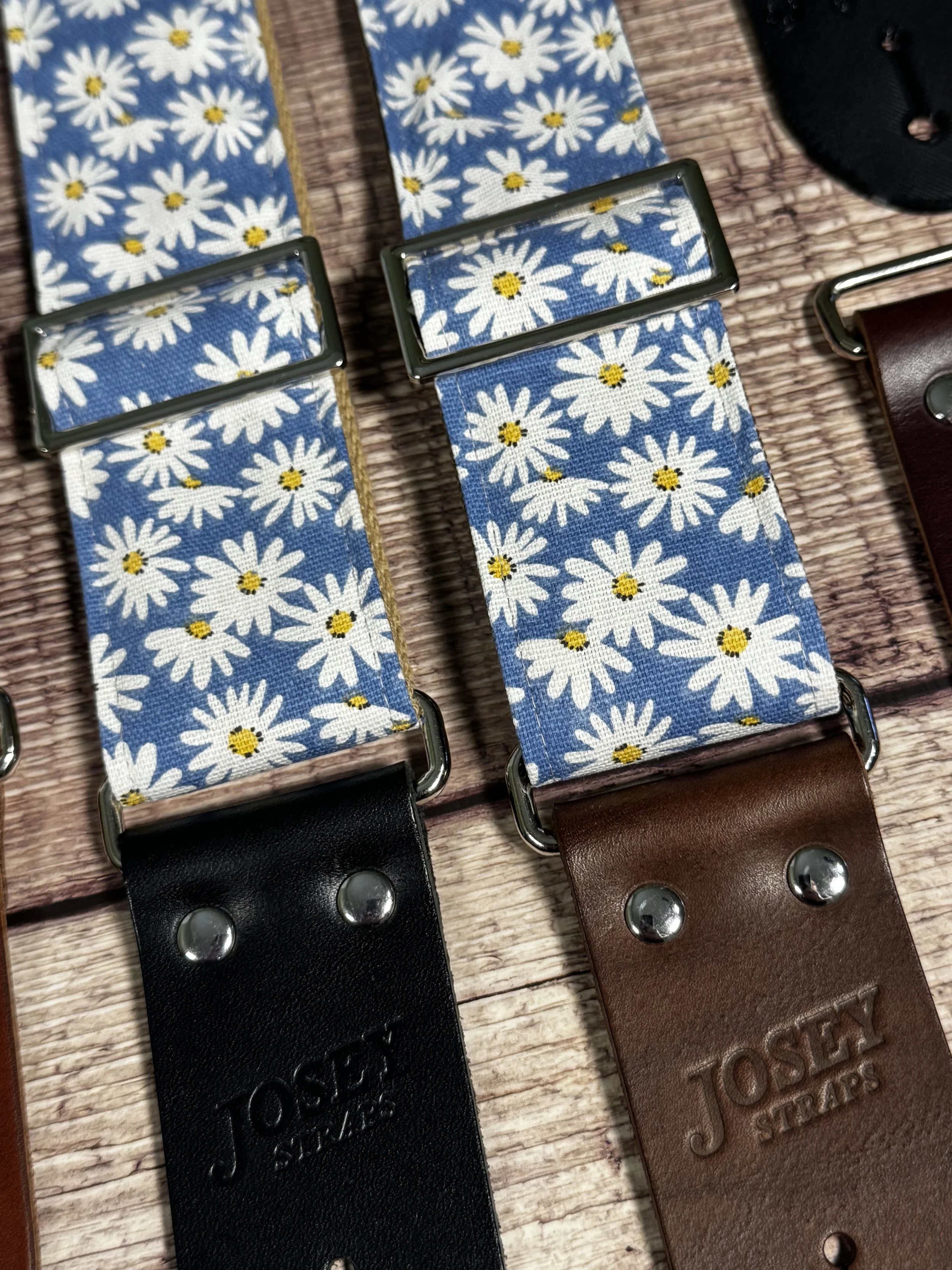 Daisy handmade floral guitar strap by Josey Straps featuring white daisies with yellow centers on a denim-blue background and premium leather ends.