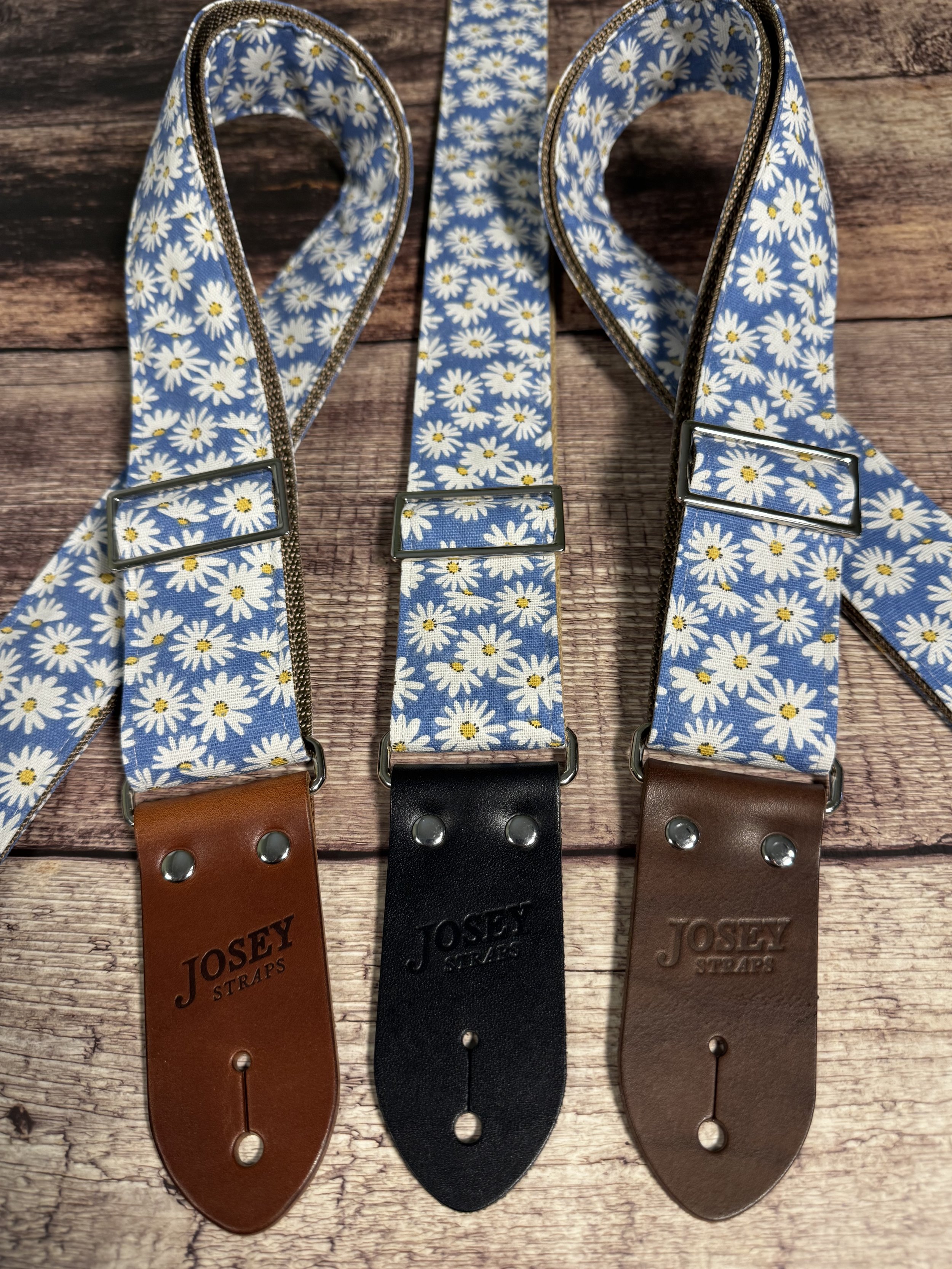 Daisy handmade floral guitar strap by Josey Straps featuring white daisies with yellow centers on a denim-blue background and premium leather ends.