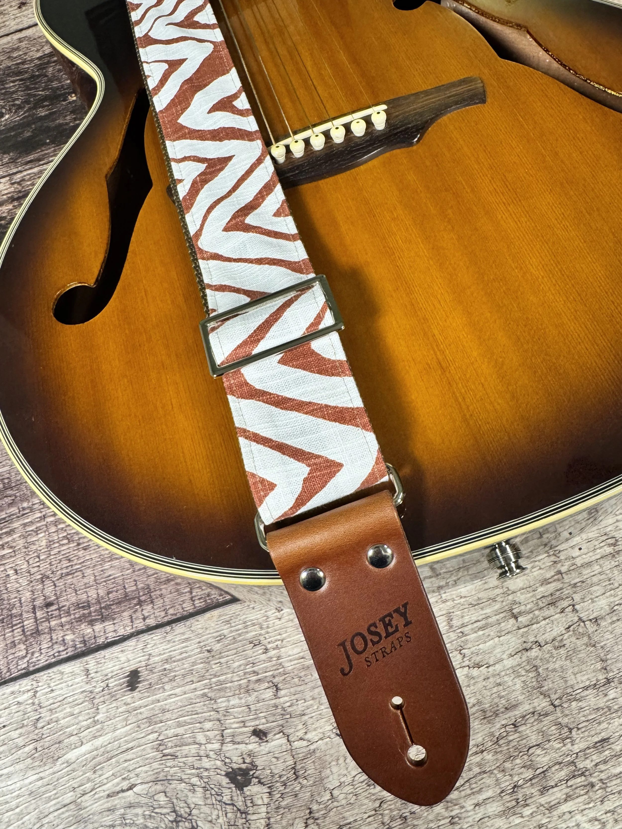 Petroglyph guitar strap featuring an earthy rust and cream geometric pattern by Josey Straps.