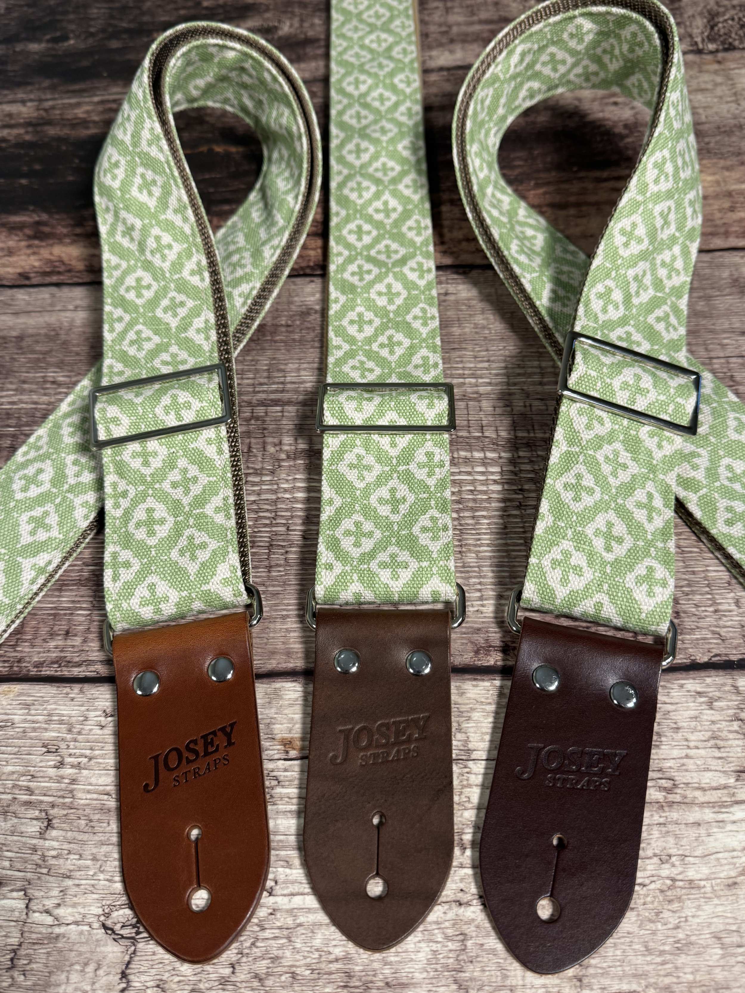 The Green House handmade guitar strap by Josey Straps featuring a sage green and cream geometric pattern with premium leather ends.