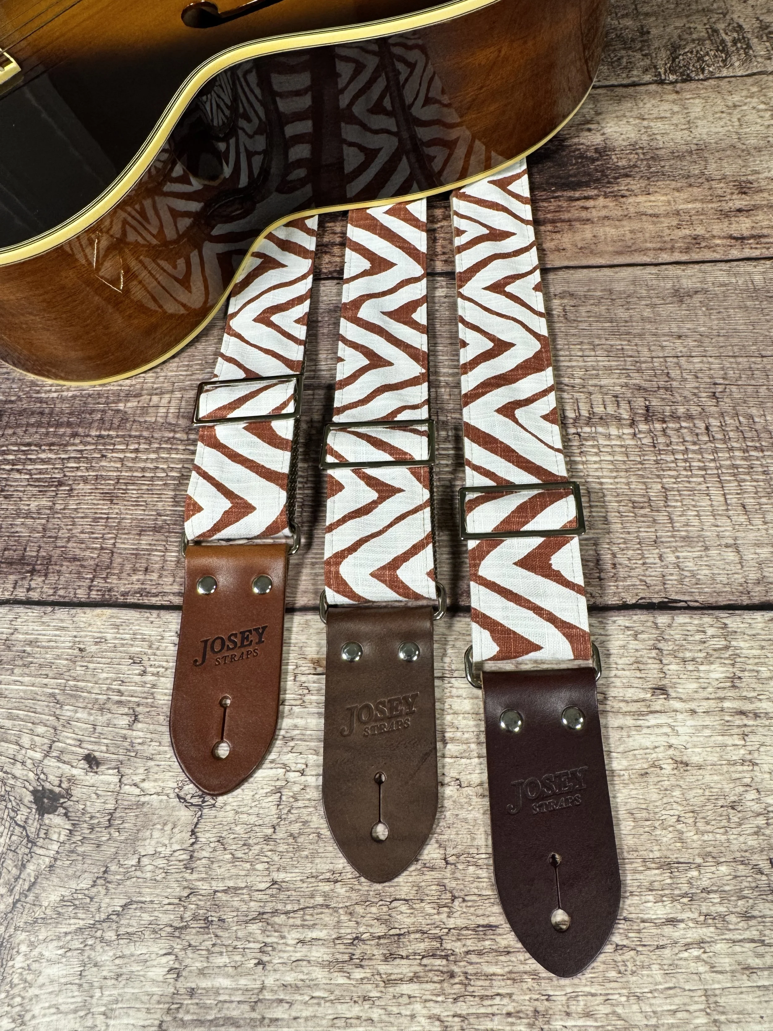 Petroglyph guitar strap featuring an earthy rust and cream geometric pattern by Josey Straps.