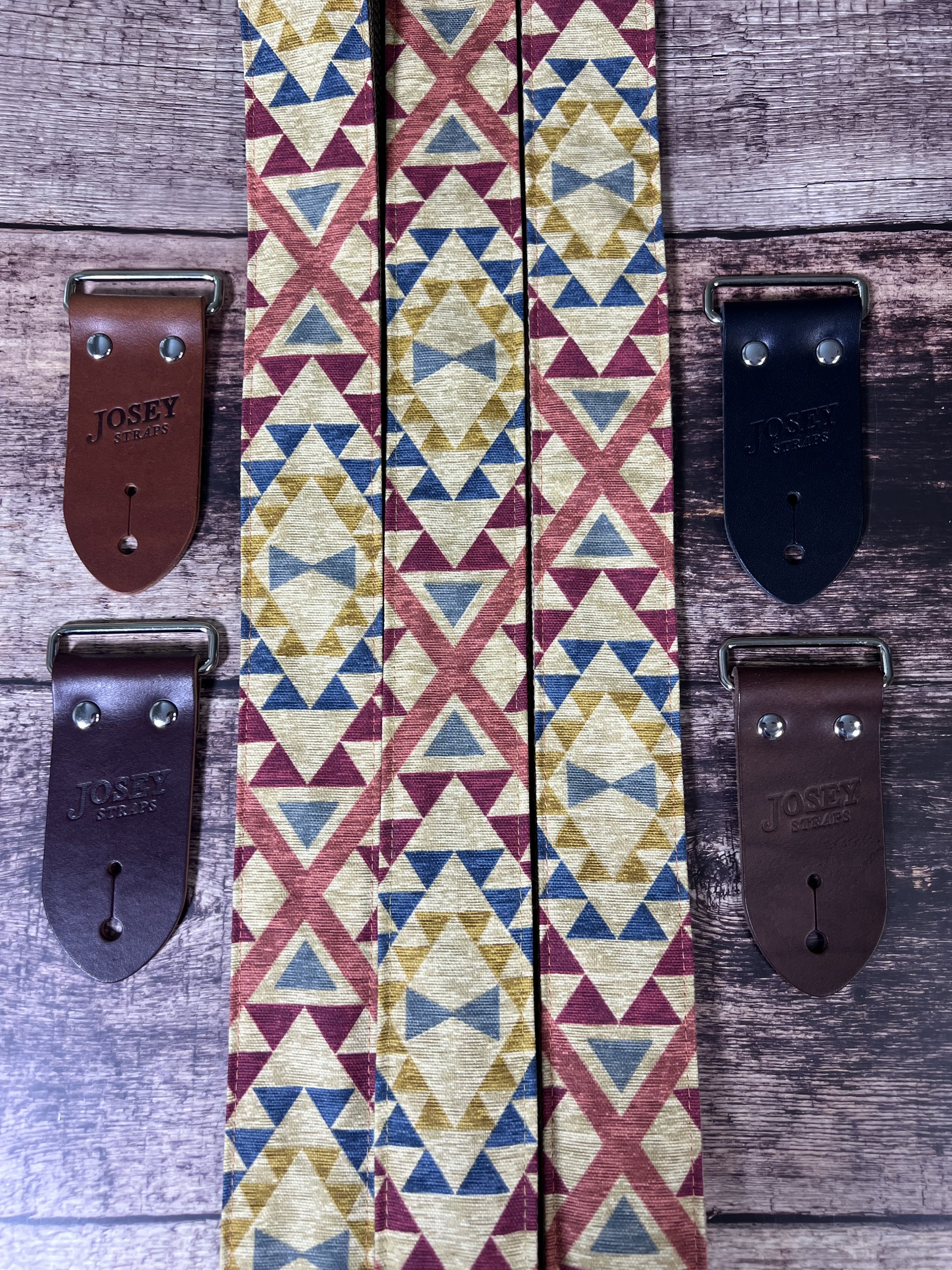 three guitar straps laid out on wood background showing leather end options