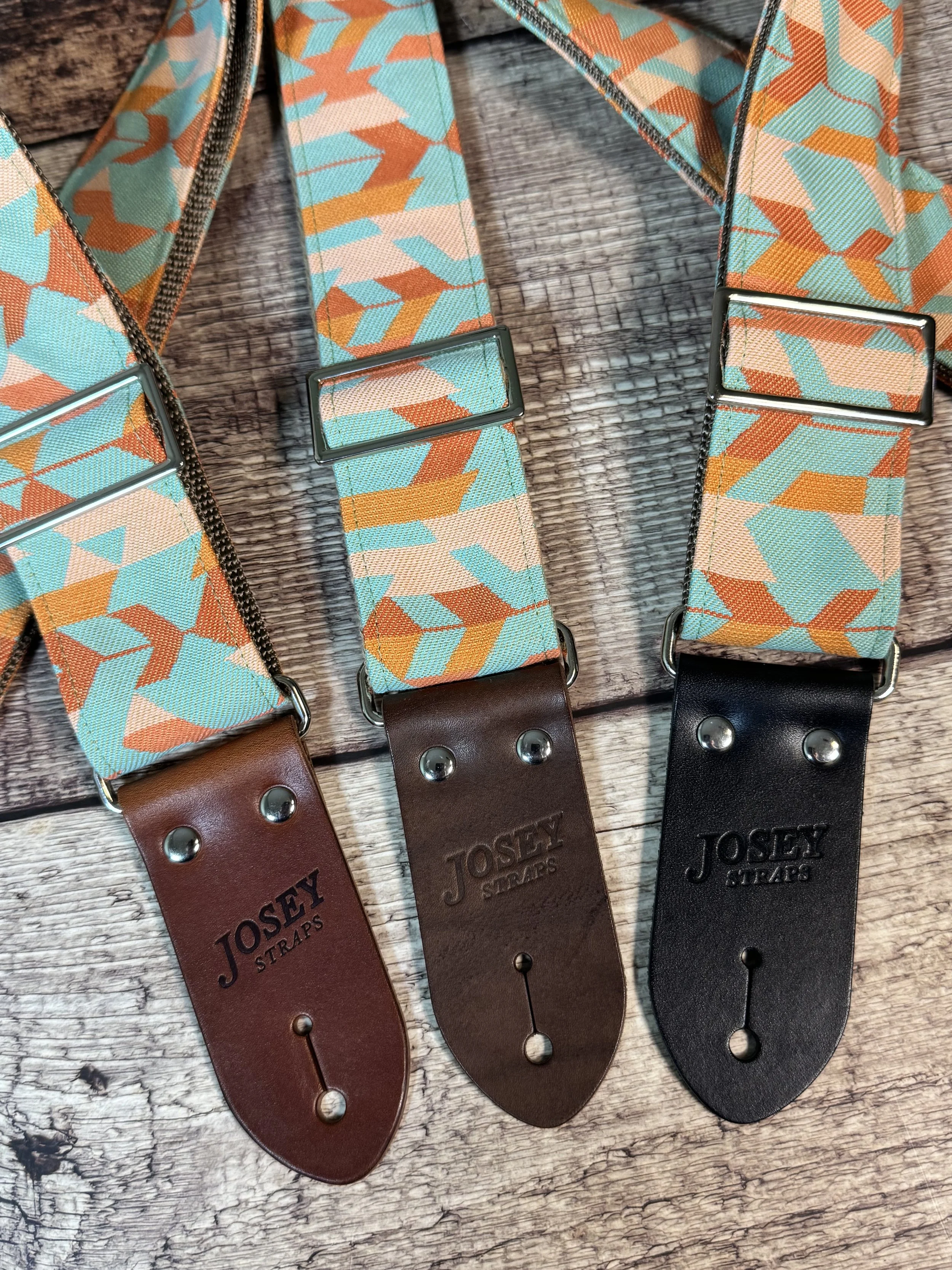 Mesa Verde handmade guitar strap by Josey Straps featuring a geometric Southwestern-inspired pattern in turquoise, terracotta, orange, and cream with premium leather ends.