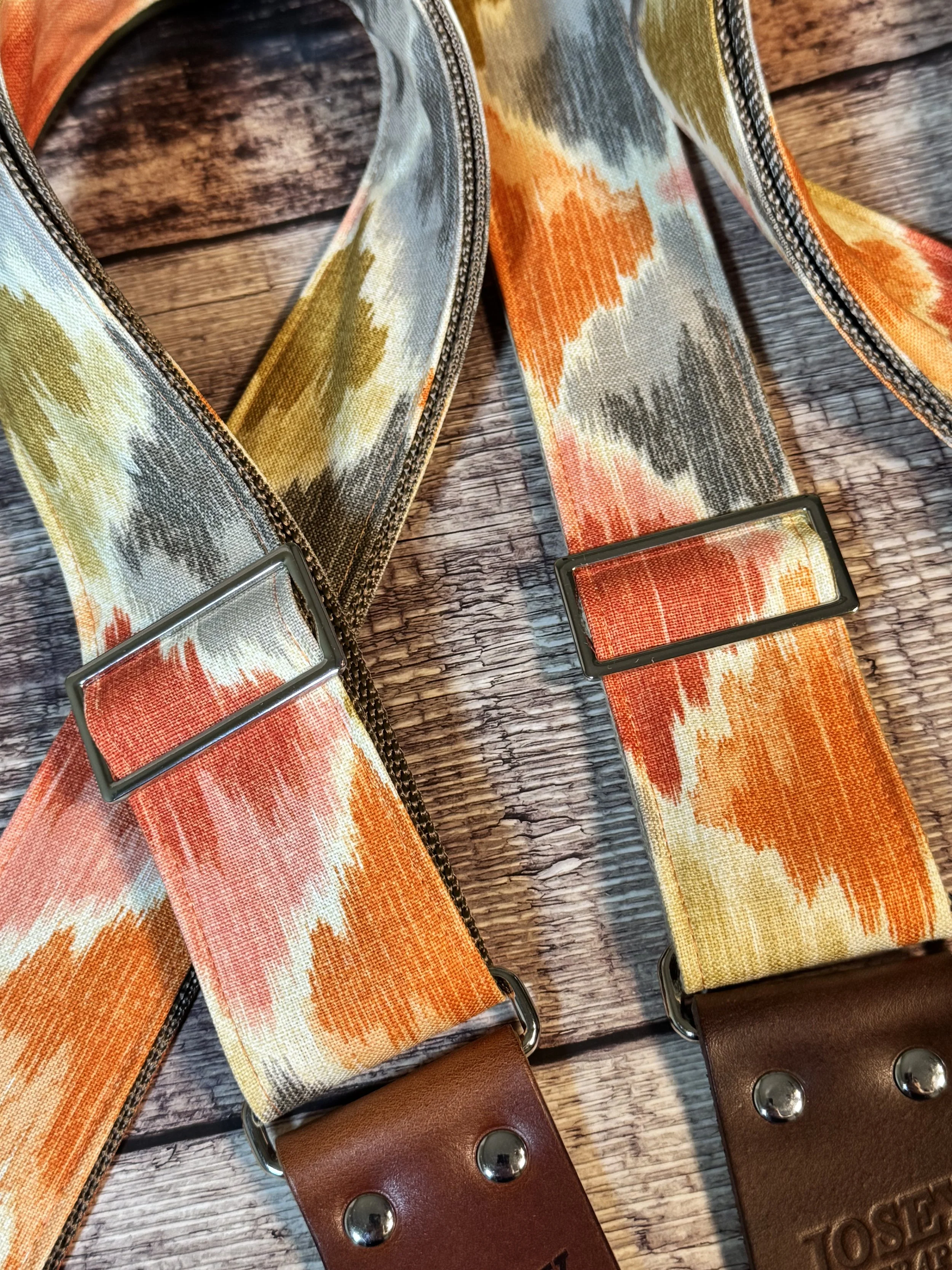 Southwestern themed guitar straps on wooden background.