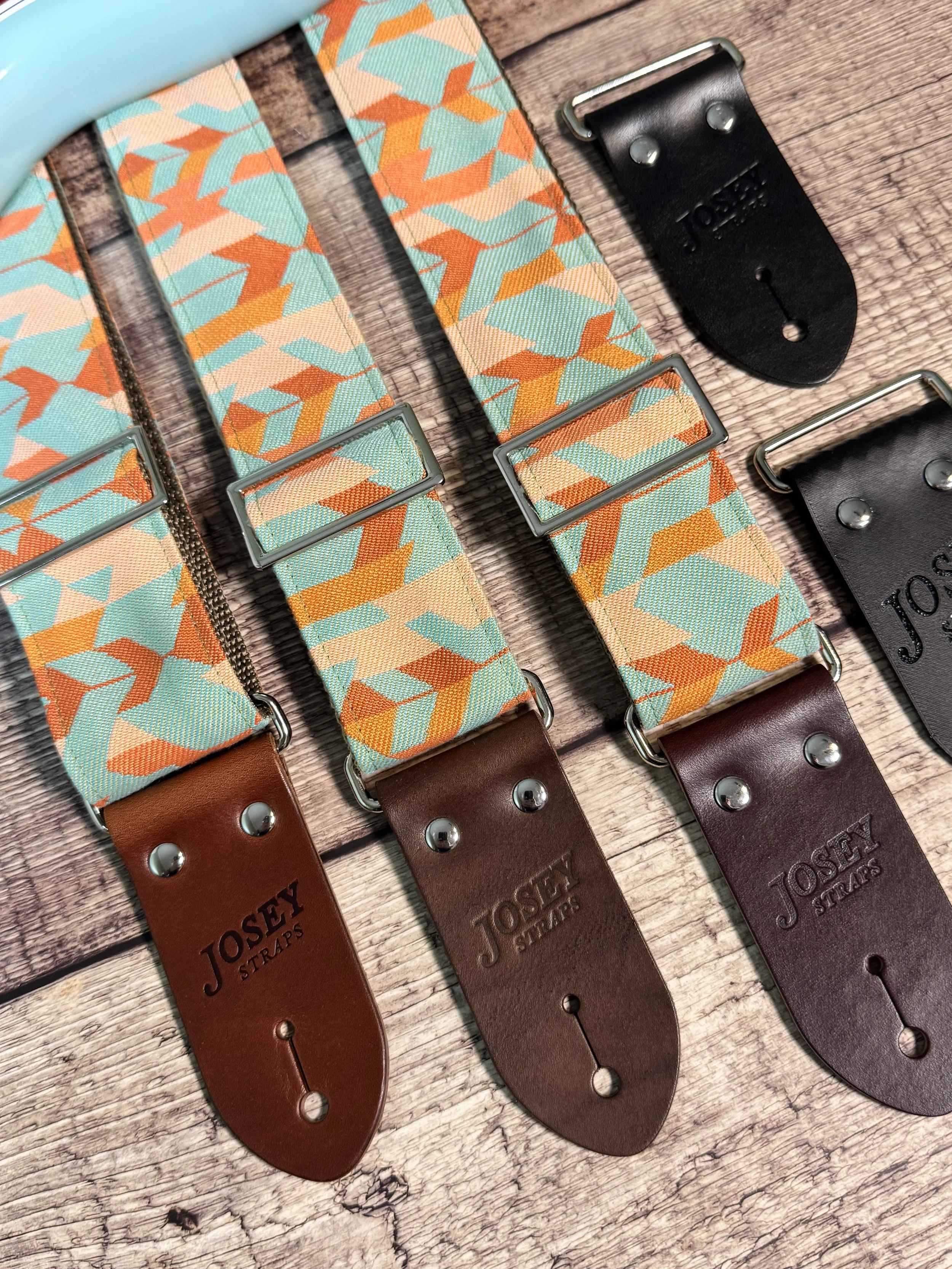 IMG_1Mesa Verde handmade guitar strap by Josey Straps featuring a geometric Southwestern-inspired pattern in turquoise, terracotta, orange, and cream with premium leather ends.