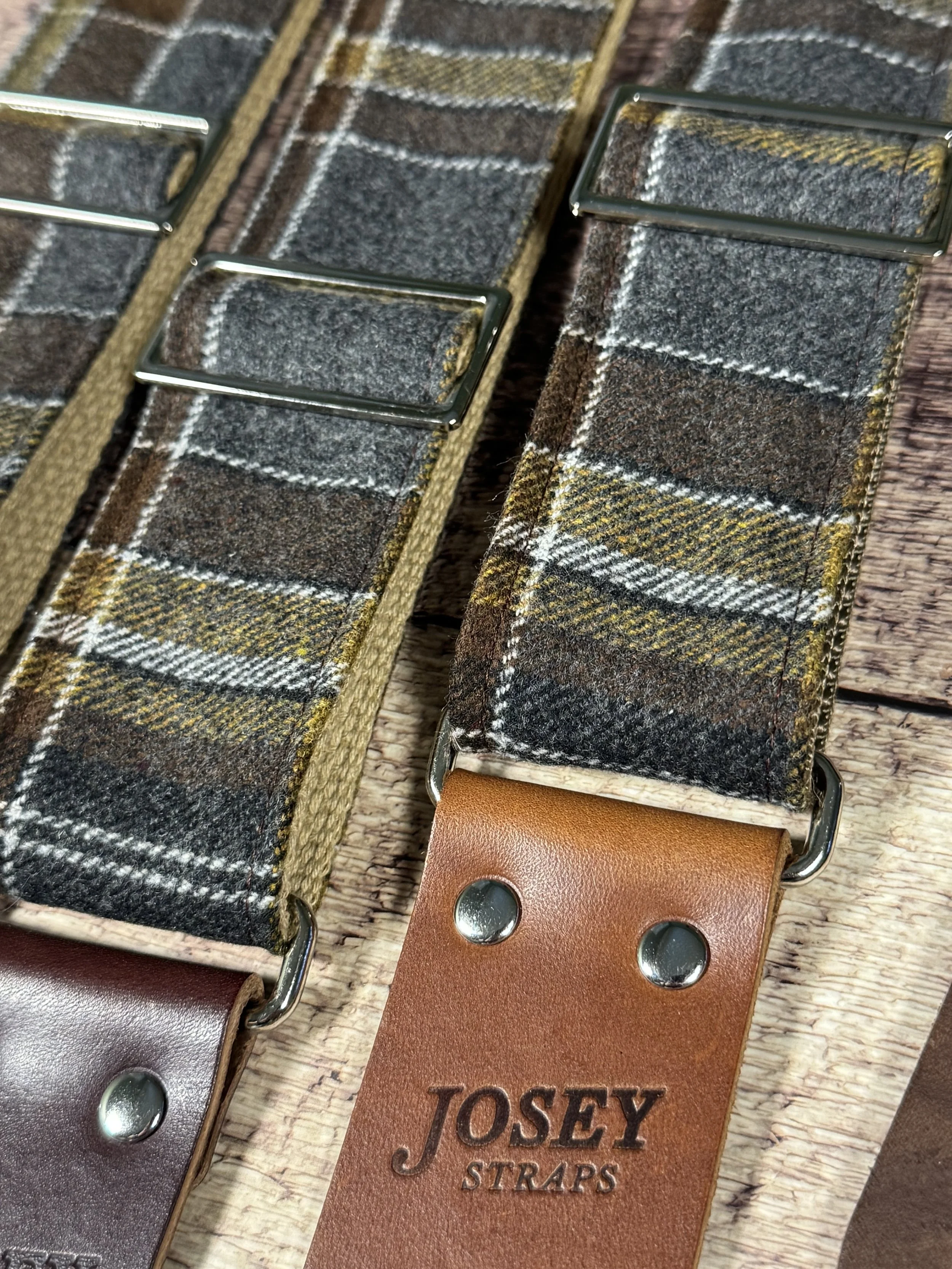 Ashes plaid guitar strap with leather ends by Josey Straps displayed on wood background