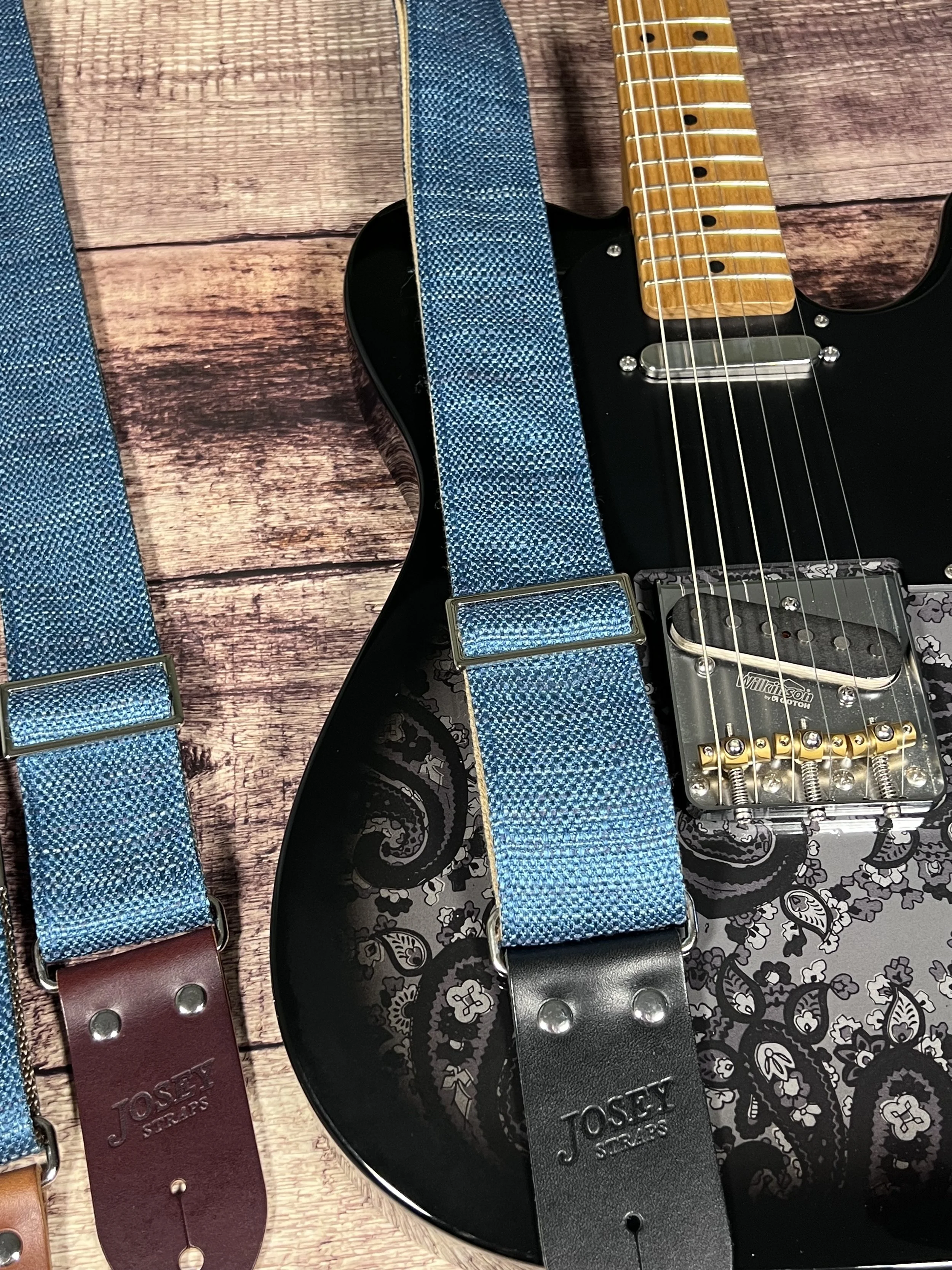 Peacock Blue woven guitar strap with blue-green texture and leather ends by Josey Straps on a black guitar.
