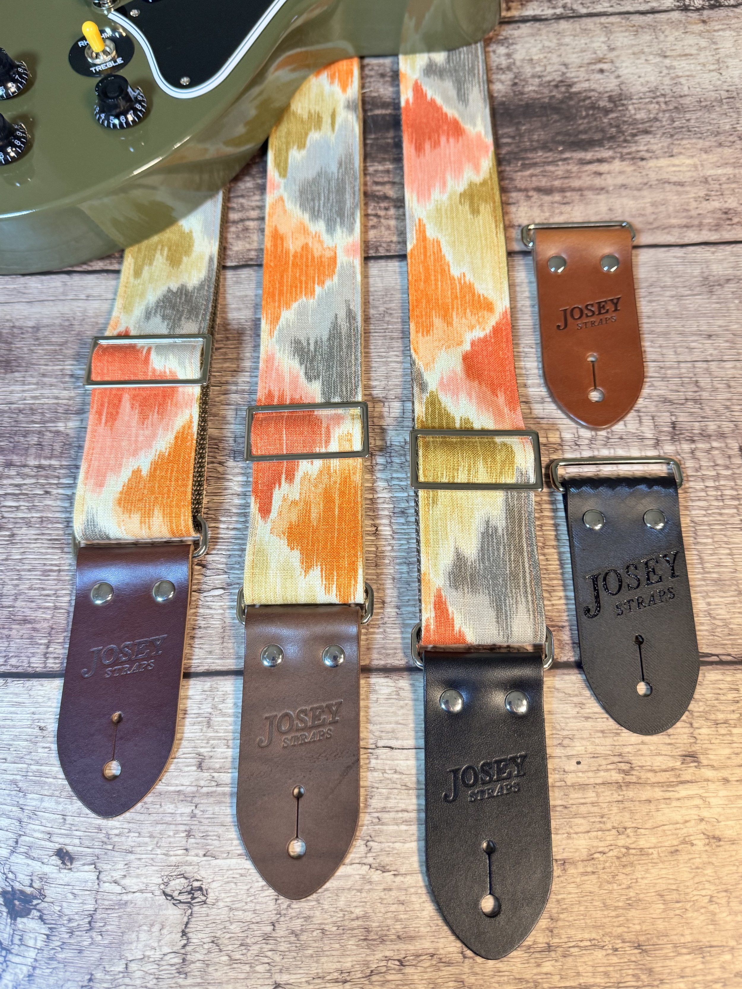 Southwestern themed guitar straps on wooden background.