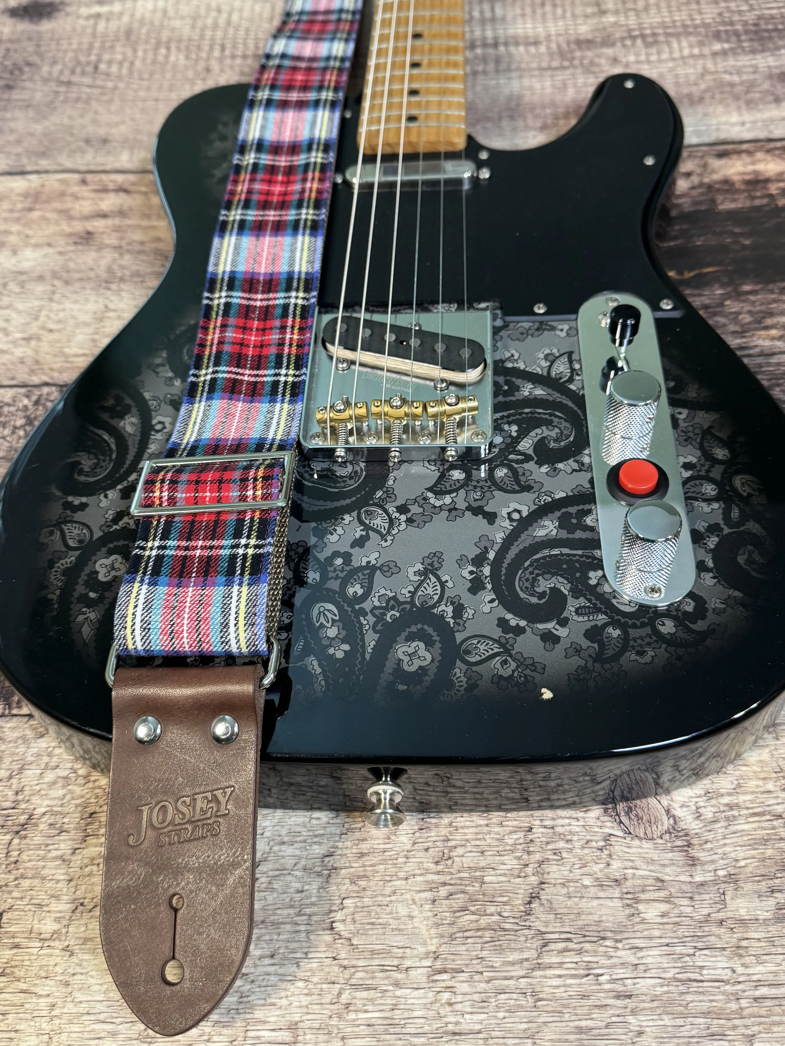 ad Plaid red and blue plaid guitar strap on black guitar with paisley pick guard