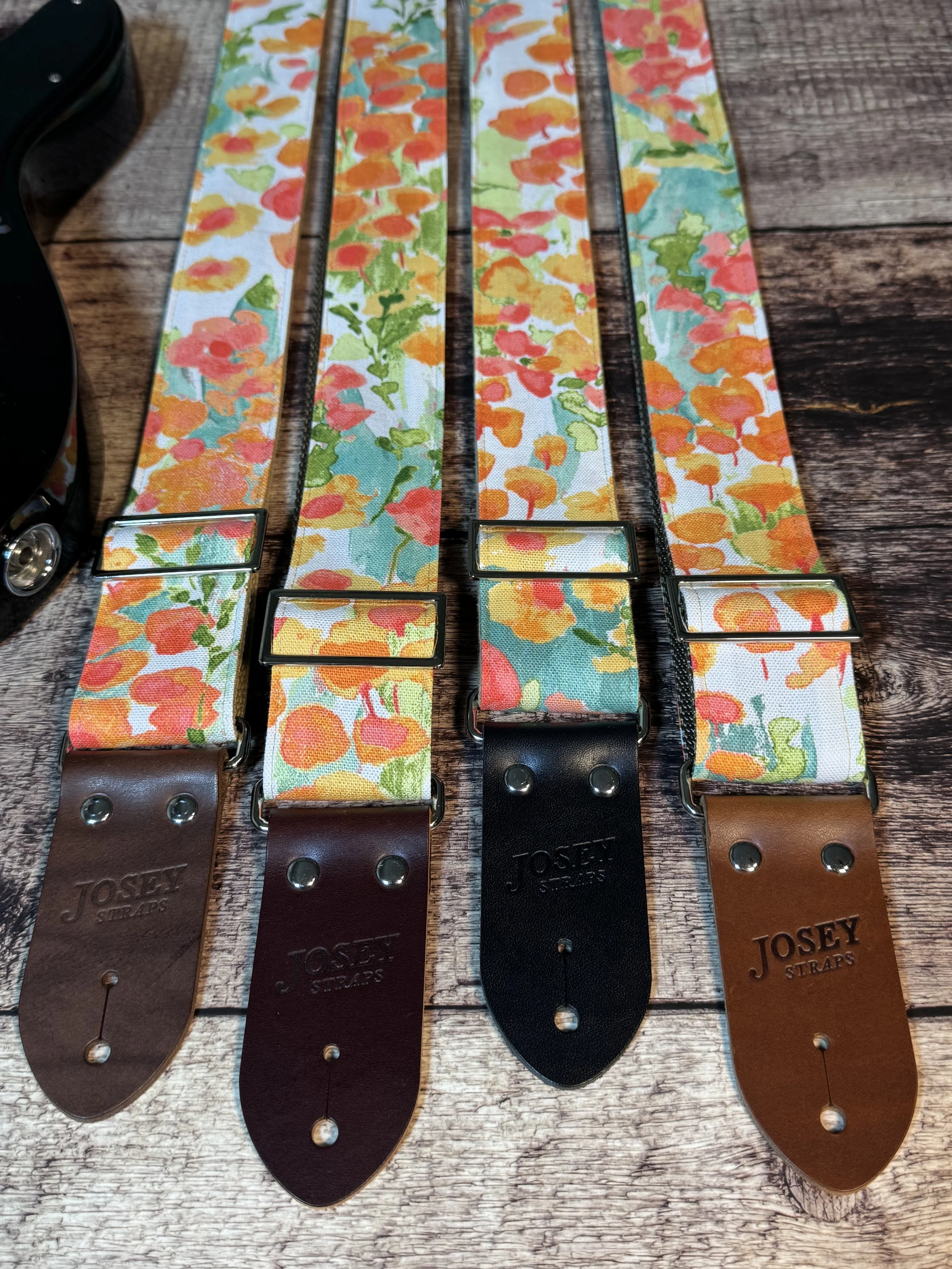 Floral guitar strap with orange, gold, and green flower pattern and leather ends by Josey Straps, In Bloom design